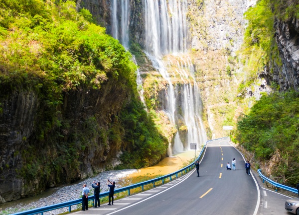 行人駐足觀看飛瀑美景。熊威攝