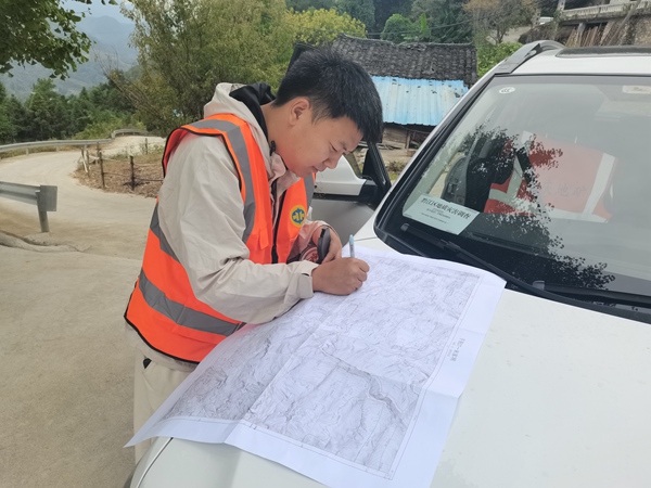 《爭分奪秒》。10月5日，川東南地質(zhì)大隊在黔江區(qū)金洞鄉(xiāng)魚泉村開展黔江南部片區(qū)1：10000小流域地質(zhì)災害精細化調(diào)查評價。圖為年輕的地質(zhì)工程師況星麟爭分奪秒進行野外地質(zhì)填圖。徐騰蛟攝