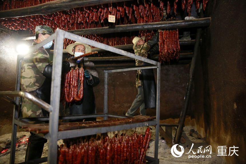 工作人將炕制好的臘味下架取出。人民網(wǎng)記者 劉政寧攝