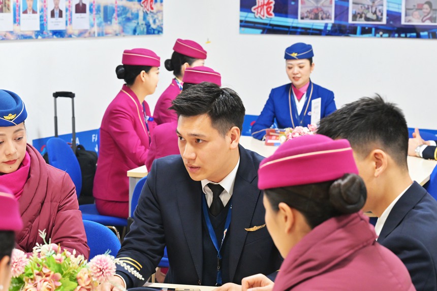 許航和楊曌分別與班組同事進(jìn)行航前準(zhǔn)備工作。鄒樂攝