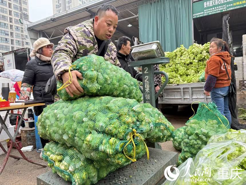 采購(gòu)商正將采購(gòu)的“兒菜”過(guò)秤。人民網(wǎng)記者 胡虹攝