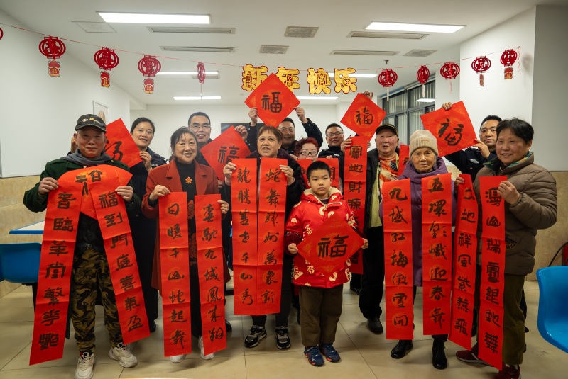 民警現(xiàn)場(chǎng)寫(xiě)春聯(lián)送給居民。渝中區(qū)公安分局供圖