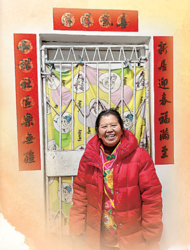 貼好春聯(lián)，彭其碧笑意盈盈。陳翔攝