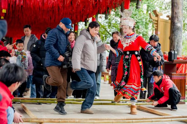 游客與嬌阿依歡跳竹竿舞。景區(qū)供圖