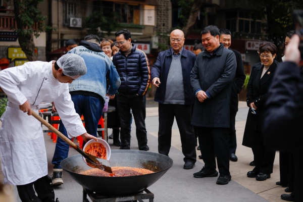 半坡聚落的火鍋店老板現(xiàn)場(chǎng)傳授火鍋炒料技巧。九龍坡區(qū)社區(qū)教育學(xué)院供圖