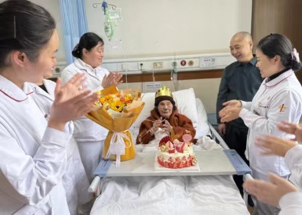 醫(yī)護(hù)人員與老人一起開(kāi)心地過(guò)百歲生日。巴南區(qū)融媒體中心供圖