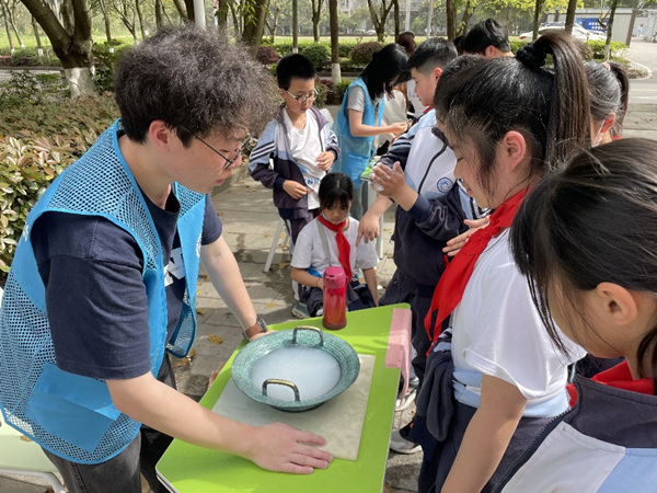 學(xué)生們?cè)趯?shí)驗(yàn)樓外體驗(yàn)趣味實(shí)驗(yàn)。重慶師范大學(xué)供圖