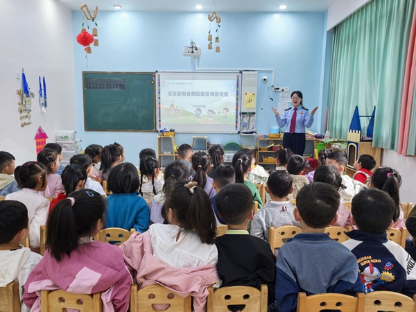 在石柱縣育之星幼兒園活動教室里，稅務(wù)人員播放稅收普法話劇《喜洋洋與灰太狼之稅收大作戰(zhàn)》，通過寓教于樂的形式為小朋友們闡釋稅收的含義。許園攝