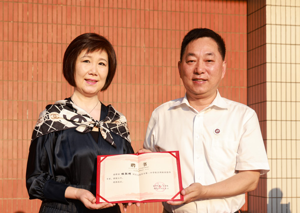 重慶一中黨委書記唐宏宇為程聯(lián)群頒發(fā)聘書。曾英豪攝