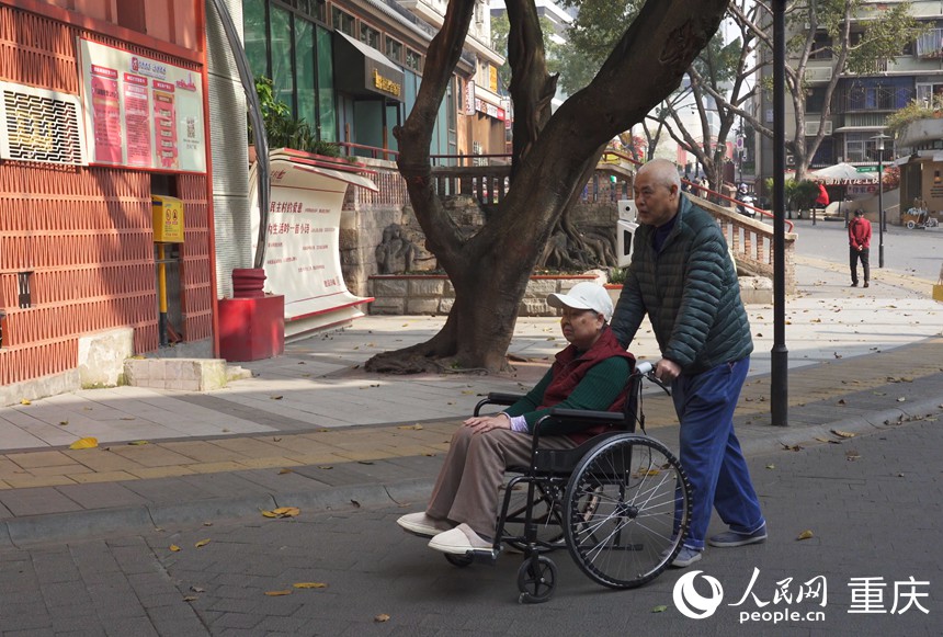 涂安全推著徐紅在社區(qū)散步。人民網(wǎng)記者 劉祎攝