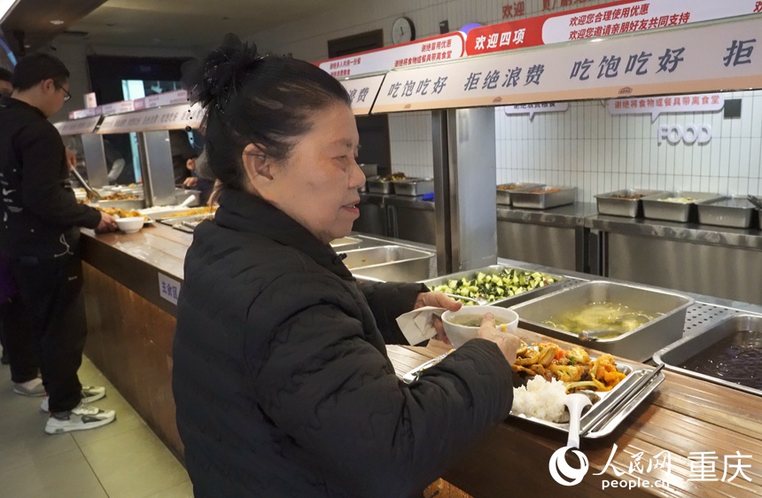 彭其碧在社區(qū)食堂打飯。人民網(wǎng)記者 劉祎攝