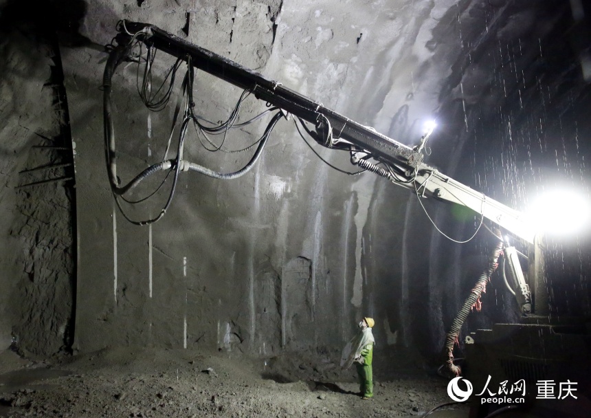 施工人員身穿雨衣正在進(jìn)行噴射混凝土作業(yè)。人民網(wǎng)記者 劉政寧攝