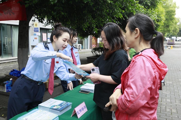 在南岸區(qū)雞冠石鎮(zhèn)石門社區(qū)，稅務部門設置稅費宣傳咨詢服務臺，向居民發(fā)放宣傳手冊，解答涉稅疑難問題。蔣宜非攝