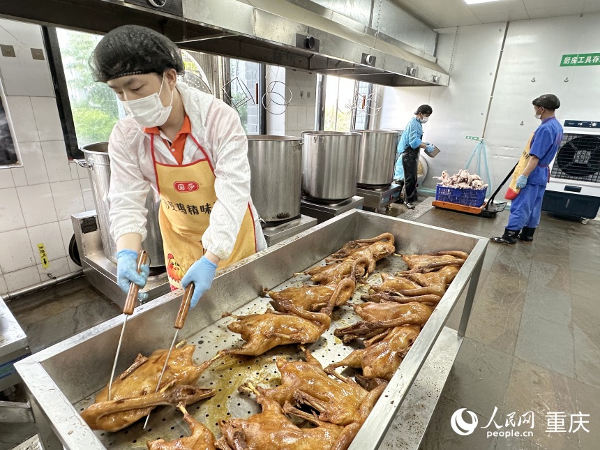 “鵝嫂”鹵鵝生產(chǎn)車間，工人將鹵制好的鹵鵝從鍋中取出冷卻。人民網(wǎng)記者 劉政寧攝