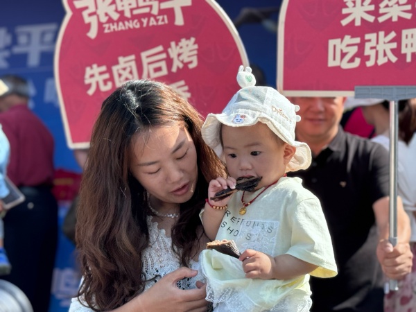 小朋友免費(fèi)試吃鹵烤鴨。陳俊攝