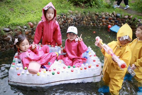 孩子們在自己用廢舊瓶子做的小船上玩得不亦樂乎。唐文蕤攝