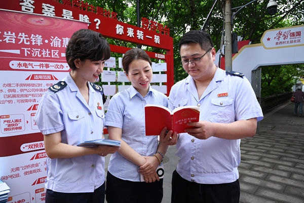 稅務(wù)總局駐重慶特派辦和渝中區(qū)稅務(wù)局工作人員在嘉西村主題社區(qū)為市民介紹民法典相關(guān)內(nèi)容。徐佑君攝