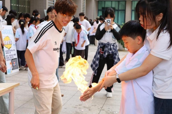 小朋友們在室外廣場體驗“火焰掌”實驗。重慶師范大學(xué)供圖