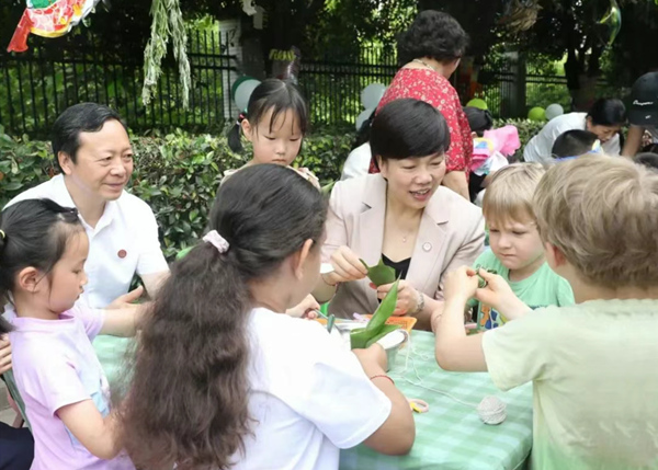 重慶師范大學(xué)黨委書記張艷與孩子們一起包粽子。重慶師范大學(xué)附屬幼兒園供圖