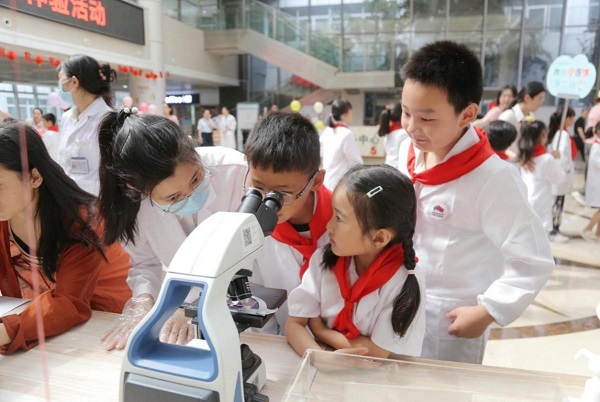 5月24日，“小醫(yī)生”們通過顯微鏡探索微觀世界。唐文蕤攝