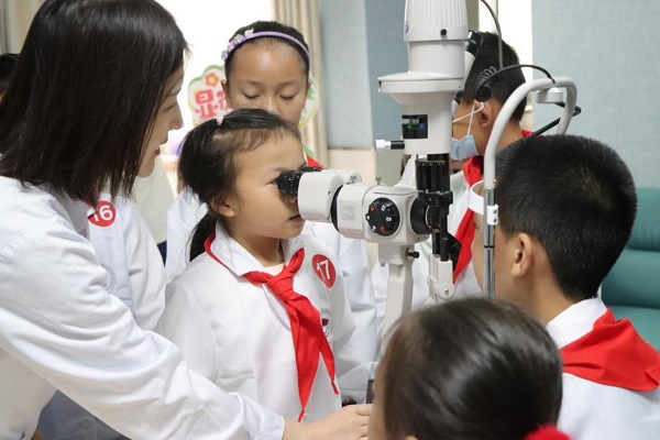 6月7日，“小醫(yī)生”們體驗使用眼科裂隙燈。重醫(yī)附屬大學城醫(yī)院供圖
