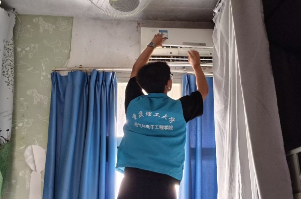 志愿者正在取下空調(diào)濾網(wǎng)。重慶理工大學(xué)供圖