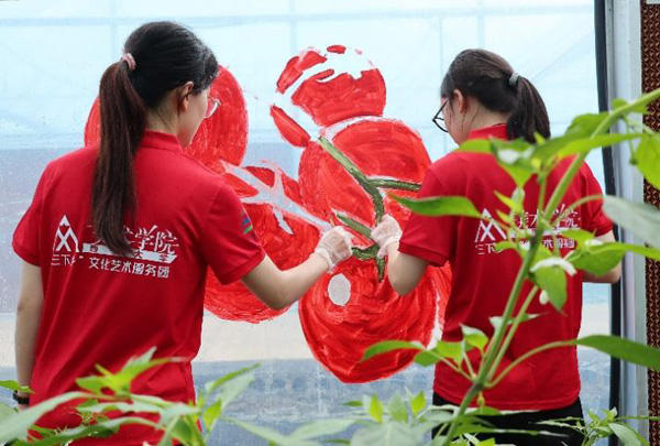 志愿者在大棚外立面進(jìn)行主題繪畫(huà)創(chuàng)作。西南大學(xué)供圖