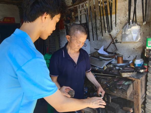 服務(wù)隊(duì)成員采訪手工木秤制作者王澤喜老人。重慶財(cái)經(jīng)學(xué)院供圖