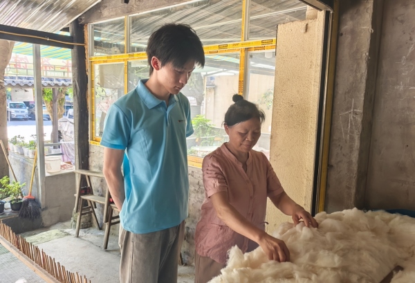 服務(wù)隊(duì)成員采訪棉被手藝人。重慶財(cái)經(jīng)學(xué)院供圖