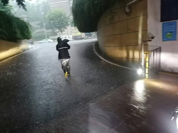 招商依云江灣物業(yè)工作人員正緊急運(yùn)送防汛沙袋封堵車庫入口，防止雨水倒灌。招商積余重慶公司供圖