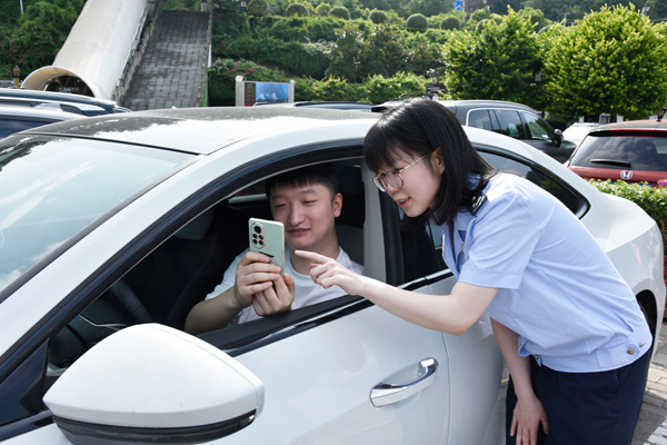 奉節(jié)縣稅務(wù)人員輔導(dǎo)市民支付停車費(fèi)后查看發(fā)票。蔡仲垚攝