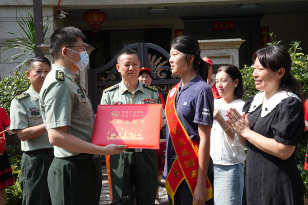 網(wǎng)絡(luò)空間部隊信息工程大學代表向付思然頒發(fā)錄取通知書。唐文蕤攝