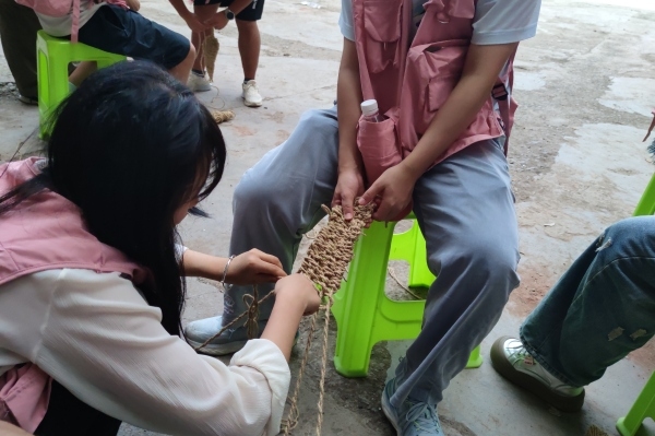 團(tuán)隊(duì)成員體驗(yàn)編草鞋。重慶移通學(xué)院供圖