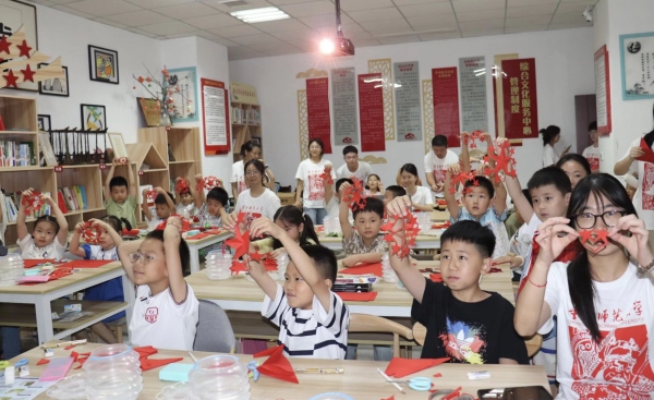 實踐團成員與孩子們共同創(chuàng)作剪紙作品。重慶師范大學(xué)美術(shù)學(xué)院供圖