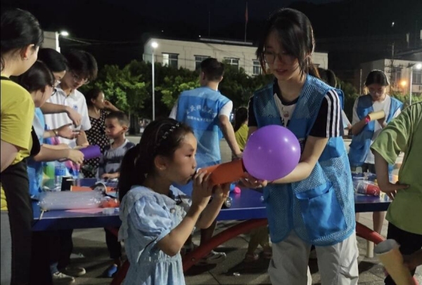 志愿者和小朋友一起體驗“火箭”升空。重慶師范大學(xué)物理與電子工程學(xué)院供圖