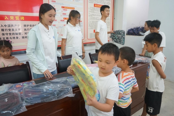 服務(wù)團成員給小朋友發(fā)放紀念品。李思諺攝