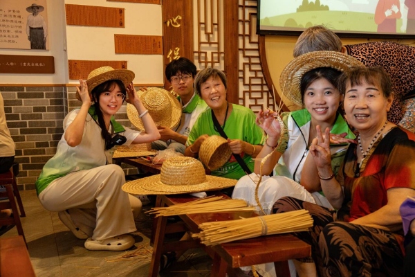 團(tuán)隊(duì)成員與回龍壩鎮(zhèn)老人一起編織草帽。甘世杰攝