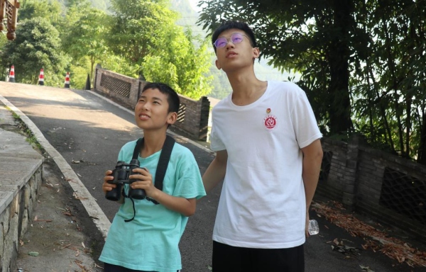 服務團成員帶領小朋友戶外觀鳥。重慶師范大學供圖