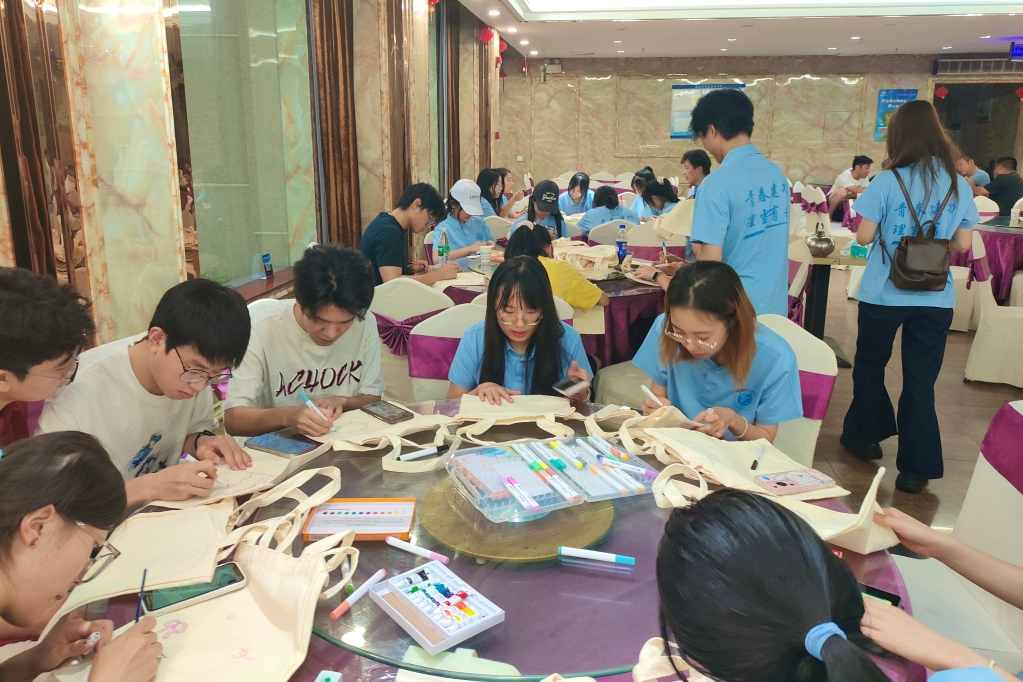 實踐團成員在帆布包上精心繪制圖案。重慶理工大學供圖