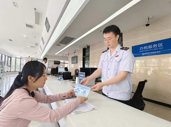 潼南區(qū)稅務(wù)人員為企業(yè)財(cái)務(wù)人員發(fā)放“成渝納稅信用修復(fù)提示卡”，引導(dǎo)其及時(shí)更正涉稅失信行為。周歡攝