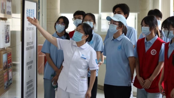 護(hù)士長為志愿者講解醫(yī)院數(shù)理醫(yī)學(xué)運(yùn)用。重慶理工大學(xué)供圖