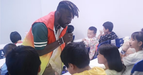實(shí)踐團(tuán)留學(xué)生志愿者用外語與兒童對(duì)話。鄭佳欣攝