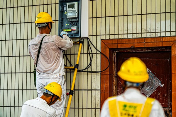 電力員工安裝動(dòng)力電表。國(guó)網(wǎng)永川供電公司供圖