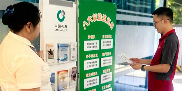 為快遞小哥撐起一片陰涼。中國人壽壽險(xiǎn)重慶市分公司供圖