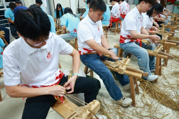成員們體驗(yàn)編草鞋。重慶工商職業(yè)學(xué)院供圖