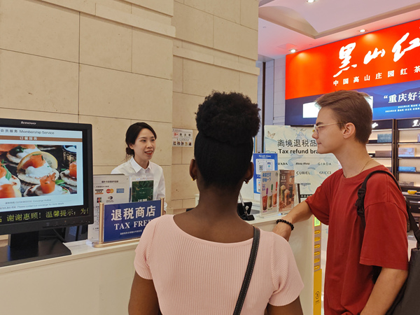 在解放碑的重慶環(huán)球金融中心離境退稅服務(wù)臺(tái)，工作人員為來自俄羅斯和西非多哥的游客介紹離境退稅“即買即退”服務(wù)。徐佑君攝