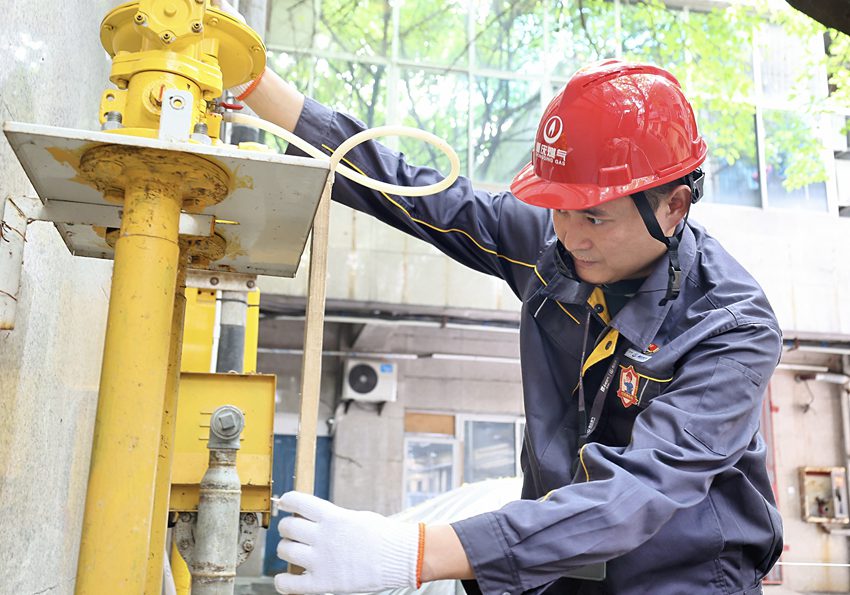 渝中區(qū)大禮堂好吃街旁，“紅巖燃小兵”對燃氣調壓箱進行日常運行維護。重慶燃氣集團供圖