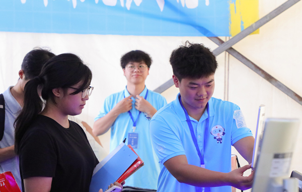 志愿者幫助新生處理報道流程。重慶城市科技學院供圖