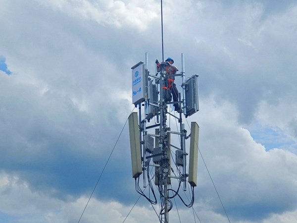 作業(yè)人員登上通信桅桿塔，進行5G-A通感一體基站安裝作業(yè)。重慶移動供圖