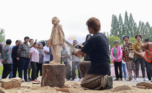 鄧?yán)?lái)街頭創(chuàng)作“木雕速寫”。曾英豪攝